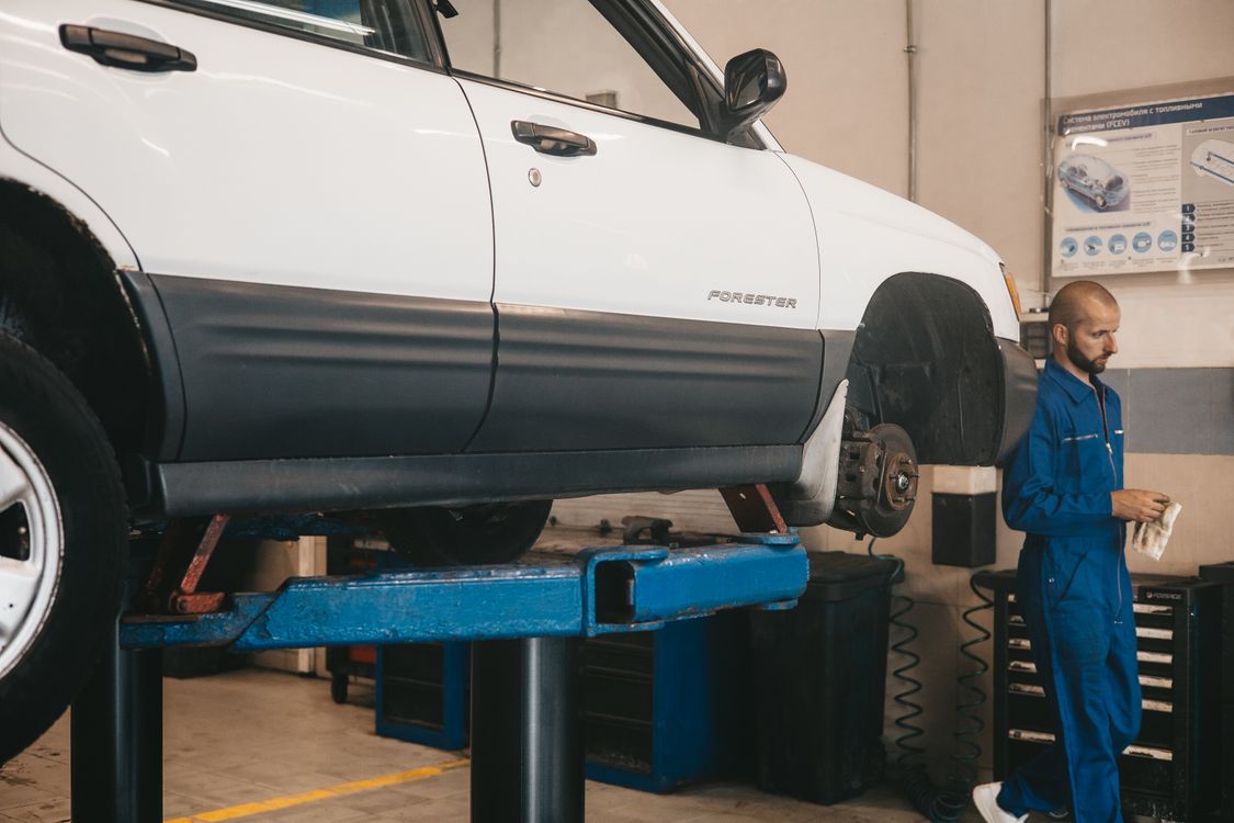 Mechanic evaluating car on lift